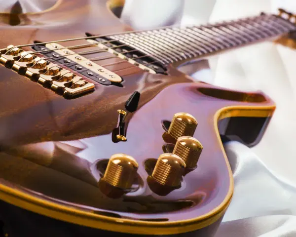 Glänzende E-Gitarre mit goldenen Details, bereit, um das Gitarre lernen zu beginnen.