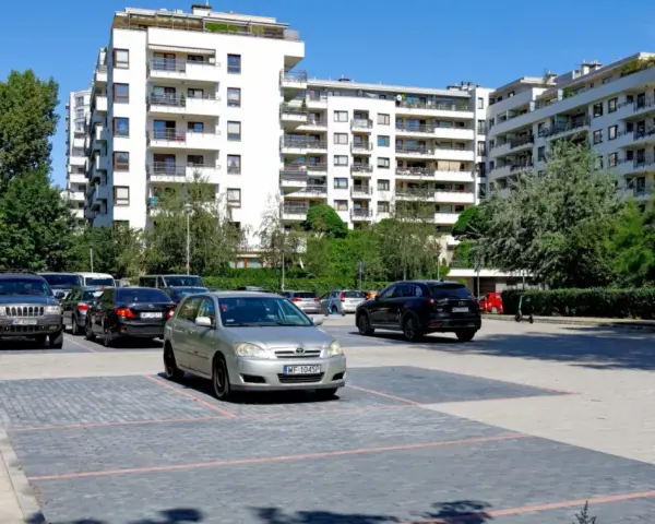 Nowoczesne osiedle w Warszawie, parking z samochodami. Zastanawiasz się, ile kosztuje kawalerka w Warszawie?