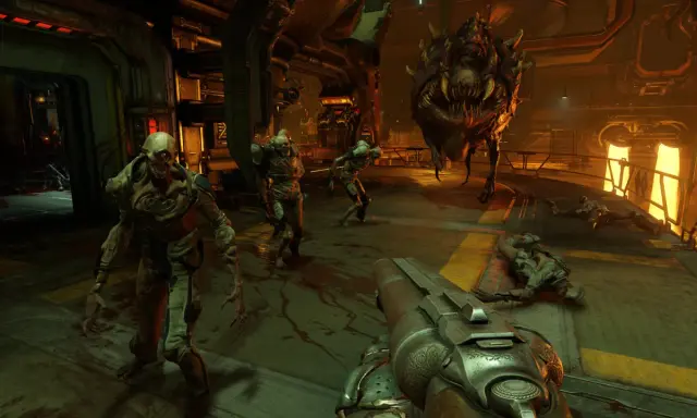 Gracz w Doom 4 walczy z hordą demonów w industrialnym otoczeniu. Na pierwszym planie widać strzelbę, a w tle potwory i martwe ciała.