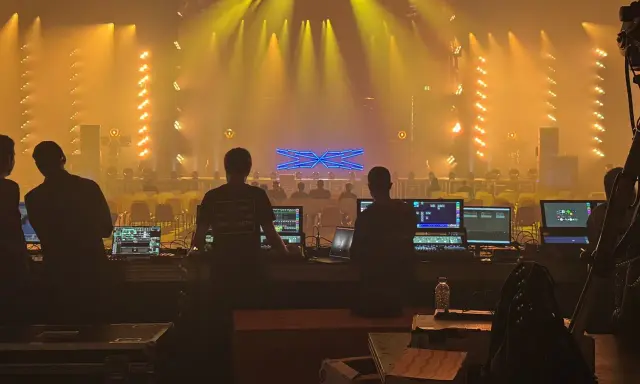 Tecnici al lavoro con console luci e schermi, pronti per un grande evento al MIR Rimini.
