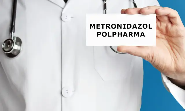 Lekarz w białym kitlu trzyma kartkę z napisem "METRONIDAZOL POLPHARMA". Metronidazol bez recepty to lek, który może pomóc w leczeniu infekcji.