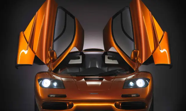 Orange McLaren F1 mit geöffneten Flügeltüren. Ein Traumauto, dessen McLaren F1 Preis unbezahlbar ist.