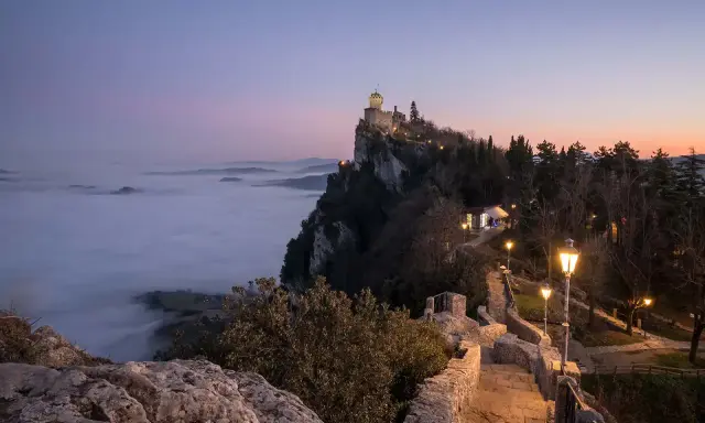 Torre Guaita domina la nebbia al tramonto, un luogo magico dove si trova San Marino.