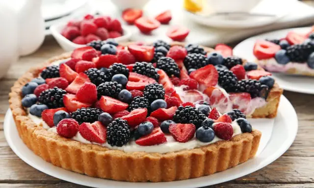 Tarta na cieście francuskim, obficie udekorowana świeżymi truskawkami, malinami, jeżynami i borówkami. Pyszny deser na letnie popołudnie.