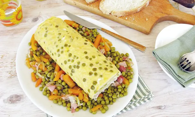 Rotolo di frittata dorato adagiato su un letto di piselli e carote. Un piatto semplice e gustoso, perfetto per un pasto leggero.