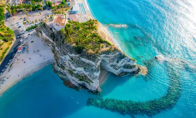 Widok z lotu ptaka na skaliste klify i piaszczyste plaże Kalabrii, z turkusową wodą Morza Śródziemnego.