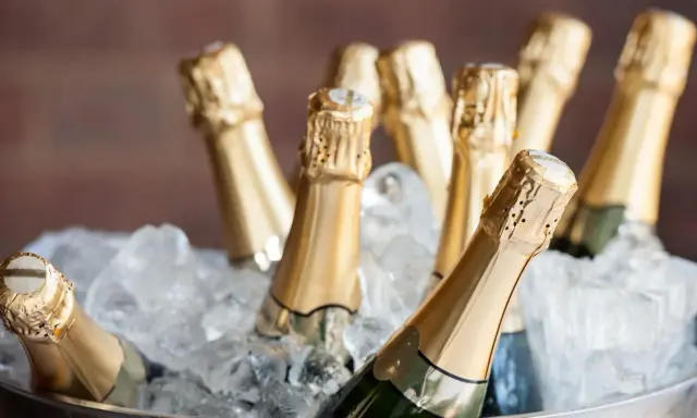 Mehrere Flaschen Prosecco kühlen in einem Eisbad. Perfekt für eine Feier, was ist Prosecco? Ein prickelnder Genuss!