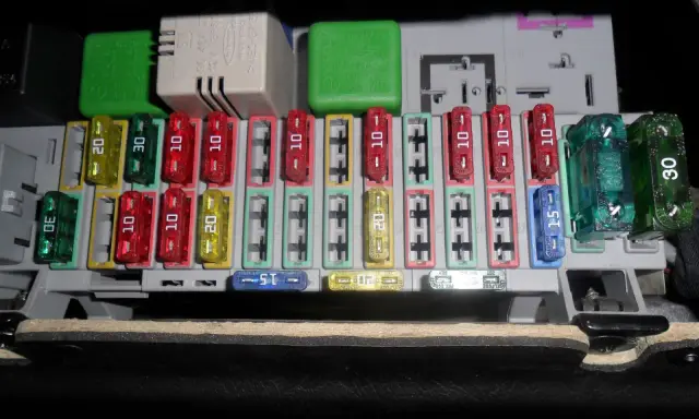 Panel bezpieczników Opel Astra H. Opis bezpieczników: zielone 30A, żółte 20A, czerwone 10A, niebieskie 15A.