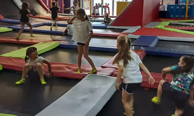 Dzieci skaczą na trampolinach w parku rozrywki. To świetne gorzów wielkopolski atrakcje dla dzieci, pełne radości i ruchu.