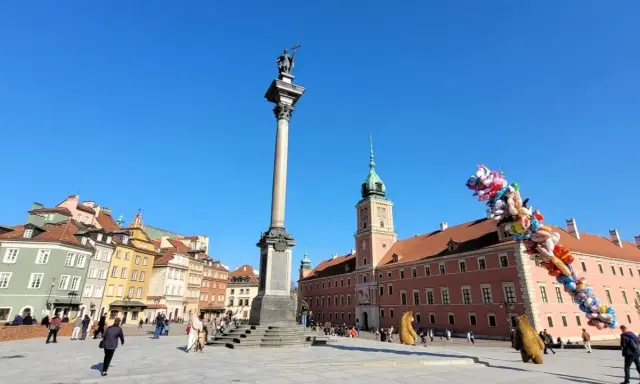 Kolumna Zygmunta i Zamek Królewski na placu w sercu starego miasta Warszawa. Balony unoszą się na błękitnym niebie.