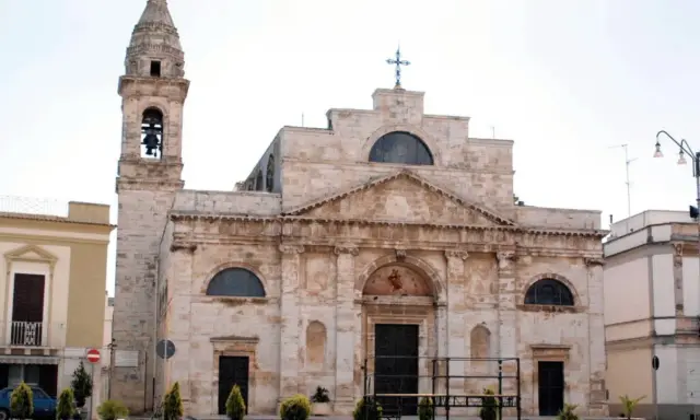 La Cattedrale di San Michele Arcangelo a Sammichele di Bari, con il suo imponente campanile e la facciata in pietra chiara, domina la piazza.