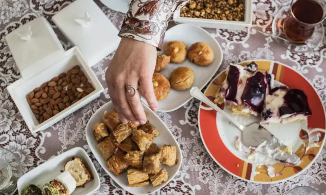 Ein Tisch voller Köstlichkeiten für das Ramadan Fest: Baklava, Kekse, Mandeln und ein Stück Kuchen.