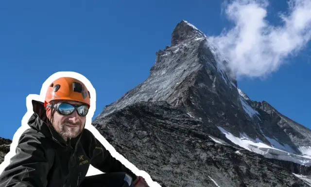 Uśmiechnięty alpinista w kasku i goglach na tle majestatycznego Matterhornu. To jego wejście na Matterhorn, cel zdobyty!