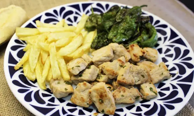 Raxo gallego con patatas fritas y pimientos de Padrón. Un plato contundente y delicioso.