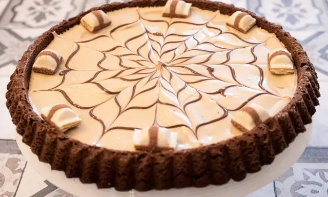 Torta Kinder Bueno con decorazione a ragnatela di cioccolato e pezzi di wafer.