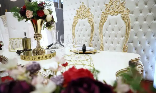 Elegancki stół z kwiatami i złotymi zdobieniami. Czy za ślub cywilny się płaci? Tutaj wszystko wygląda na luksusowe.