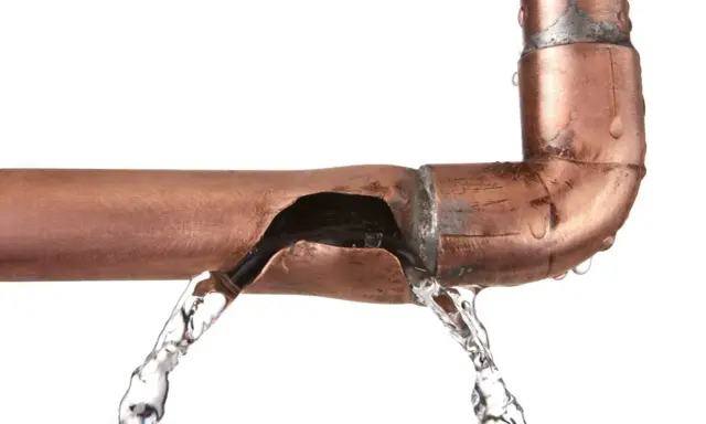 Fuite d'eau sur un tuyau en cuivre endommagé. Une solution pour réparer tuyau cuivre sans soudure est nécessaire.