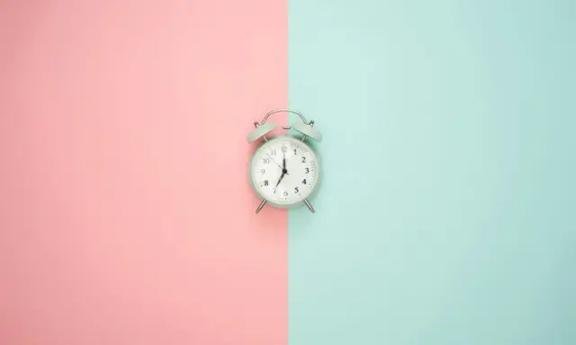 Budzik na pastelowym tle. Pokazuje 7:00, czas na rozpoczęcie dnia, czy to am, czy pm, zawsze jest dobry moment na zmianę.