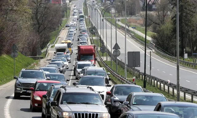 Korek na drodze, jak węzeł gordyjski, zablokował ruch. Samochody stoją w długiej kolejce, tworząc niekończący się rząd pojazdów.