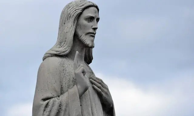 Kamienna rzeźba Jezusa z podniesionym palcem, jakby mówił słowa z psalm 102.