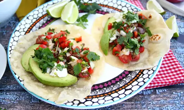 Två läckra tex mex-tacos med avokado, tomat, lök och koriander. Ett perfekt tex mex recept för en snabb och god middag.