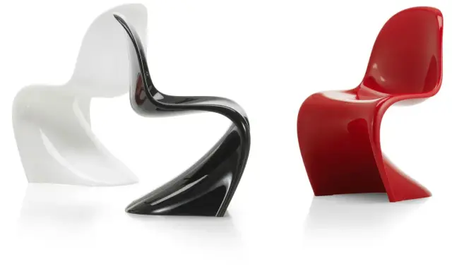 Tre sedie di design iconiche: una bianca, una nera lucida e una rossa brillante, con forme sinuose e moderne.