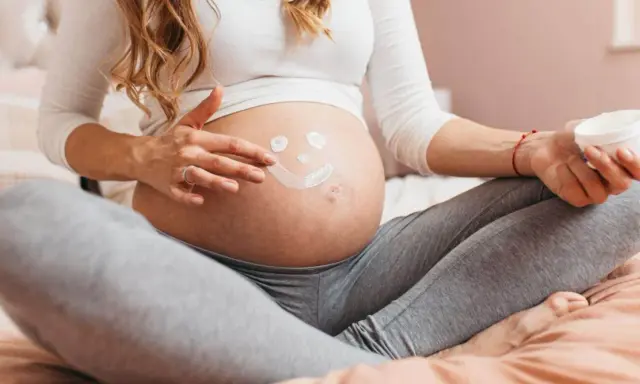 Ciężarna kobieta rysuje uśmiechniętą buźkę na brzuchu. Myśli o przyszłości, o zdrowiu dziecka i o tym, jak cenna jest krew pępowinowa.