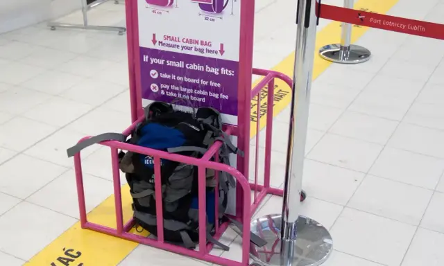 Wizzair leki w bagażu podręcznym? Sprawdź wymiary w różowym stojaku. Plecaki czekają na pomiar.