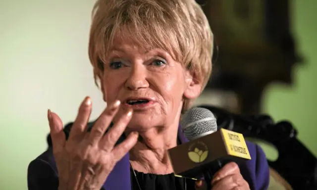 Maria Czubaszek, z mikrofonem w dłoni, gestykuluje, jakby opowiadała jedną ze swoich błyskotliwych historii. Jej cytaty wciąż bawią i skłaniają do refleksji.