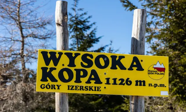 Żółta tablica informuje o szlaku na Wysoką Kopę (1126 m n.p.m.) w Górach Izerskich.
