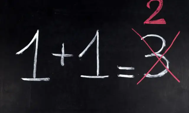 Na czarnej tablicy napisano kredą: 1+1=2. Liczba 3 jest przekreślona, jakby to był trudny egzamin dojrzałości.