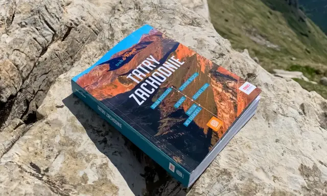 Przewodnik "Tatry Zachodnie" leży na skale. Na okładce widnieje m.in. Dolina Kościeliska.