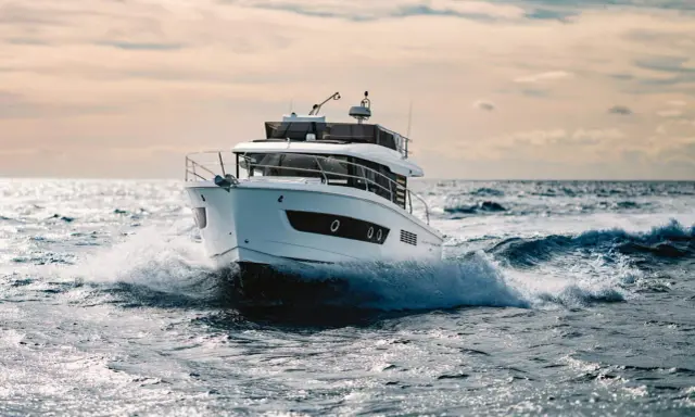 Un bateau blanc fend les vagues, le moteur de 20 cv propulsant l'embarcation à pleine vitesse.