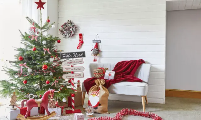 Un sapin décoré, des cadeaux et un fauteuil rouge invitent à faire des décorations de Noël. Un panneau "Pôle Nord" indique la direction.