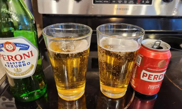 Dwa szklanki orzeźwiającego peroni piwo, obok zielona butelka i czerwona puszka. Idealne na włoskie popołudnie.