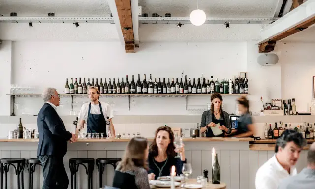 Un bar de restaurant moderne avec des employés derrière le comptoir, respectant les normes d'hygiène et de service.