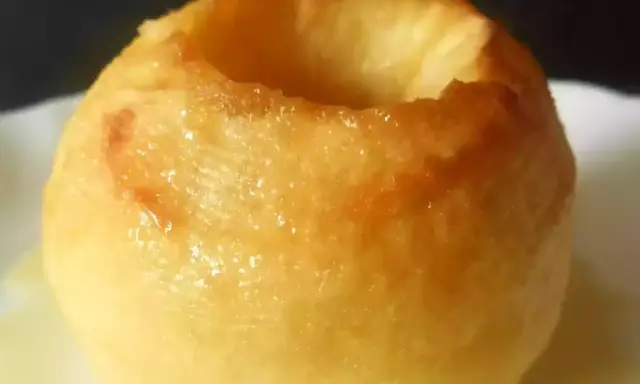 Une pomme au four dorée, creusée et prête à être garnie. Un délice simple et réconfortant.