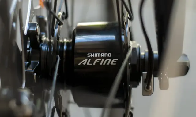 Szczegół piasty rowerowej Shimano Alfine z widocznym kablem, który jest kluczowy, by dowiedzieć się jak włączyć dynamo w rowerze.