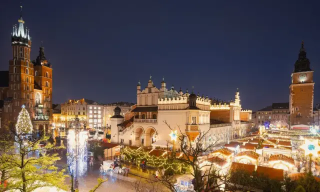 Kraków atrakcje zimą: Rynek Główny nocą, iluminacje świąteczne, Sukiennice, Kościół Mariacki i wieża ratuszowa.