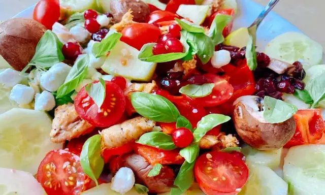 Salade colorée avec poulet, tomates, concombre, mozzarella et fruits rouges. Une excellente idée repas froid midi, fraîche et savoureuse.