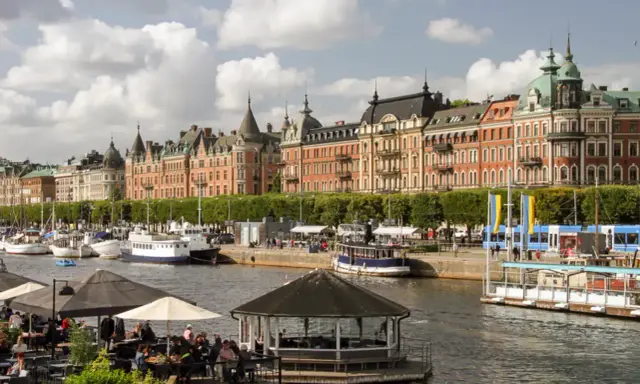 En dag i Stockholm vid vattnet med vackra byggnader, båtar och uteserveringar.