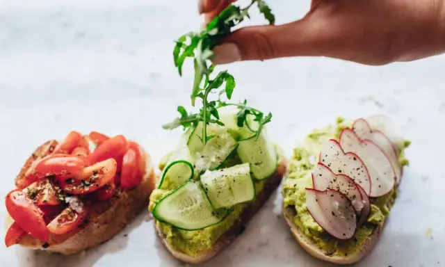 Tres tostadas gourmet: tomate, pepino y aguacate con rábano. La mejor variedad de aceite de oliva para tostadas realza sus sabores.
