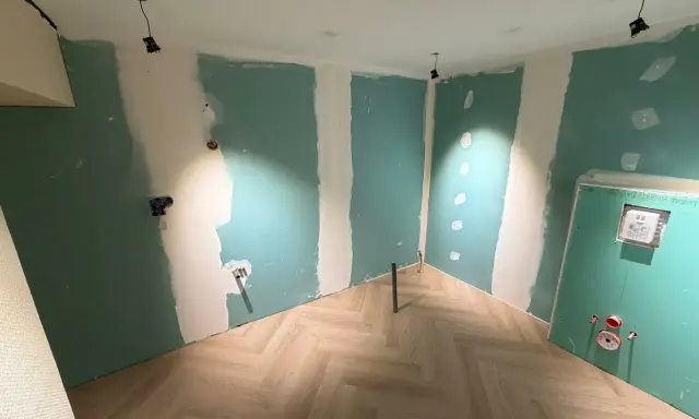 Chantier en cours : murs en Placo vert, sol parquet chevron. Idéal pour estimer le prix pose placo m2.