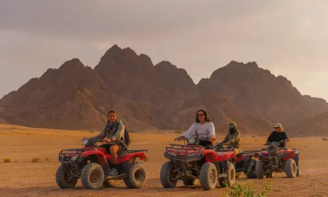 Un gruppo di persone si diverte in quad nel deserto egiziano, un'avventura indimenticabile a Sharm el Sheikh con bambini.