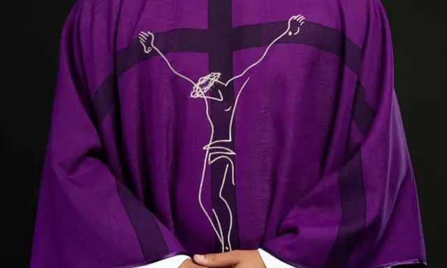 Fioletowa szata liturgiczna z haftowanym wizerunkiem Jezusa na krzyżu.