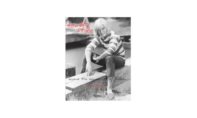 A woman with short blonde hair embodies tomboy style, wearing a striped shirt and jeans, sitting on a wooden beam. Text reads "tomboy style" and "beyond the boundaries of fashion.
