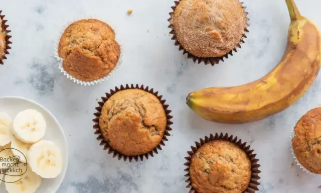 Saftige bananen muffins, ein reifer Banane und Bananenscheiben auf einem Teller. Perfekt für den Kaffeetisch.