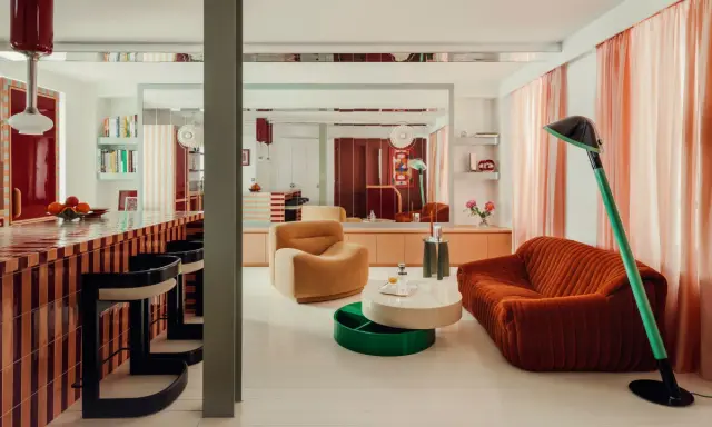 Un soggiorno con mobili colorati e un bancone da bar a righe. Stanza particolari in una casa che invita al relax e alla convivialità.