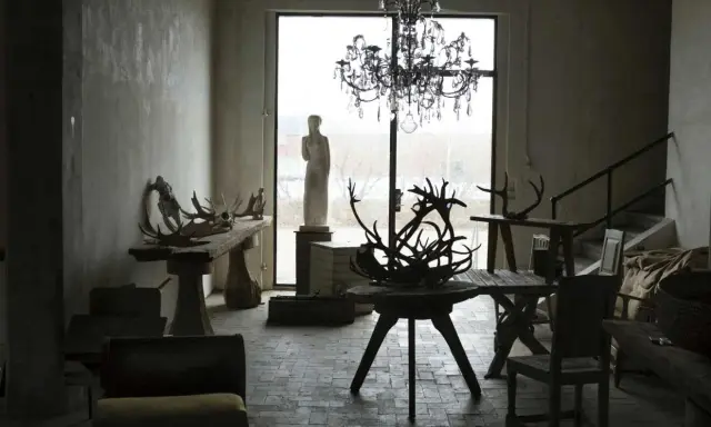 Martin Engets ateljé med rådjurshorn, en ljuskrona och en staty.