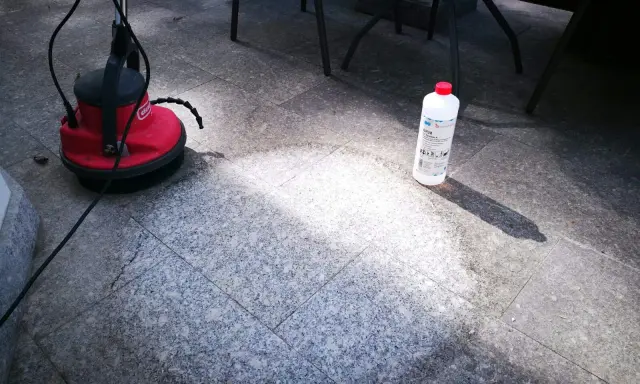 Czym czyścić granit płomieniowany? Na zdjęciu widać maszynę czyszczącą i butelkę z preparatem do czyszczenia kamienia.